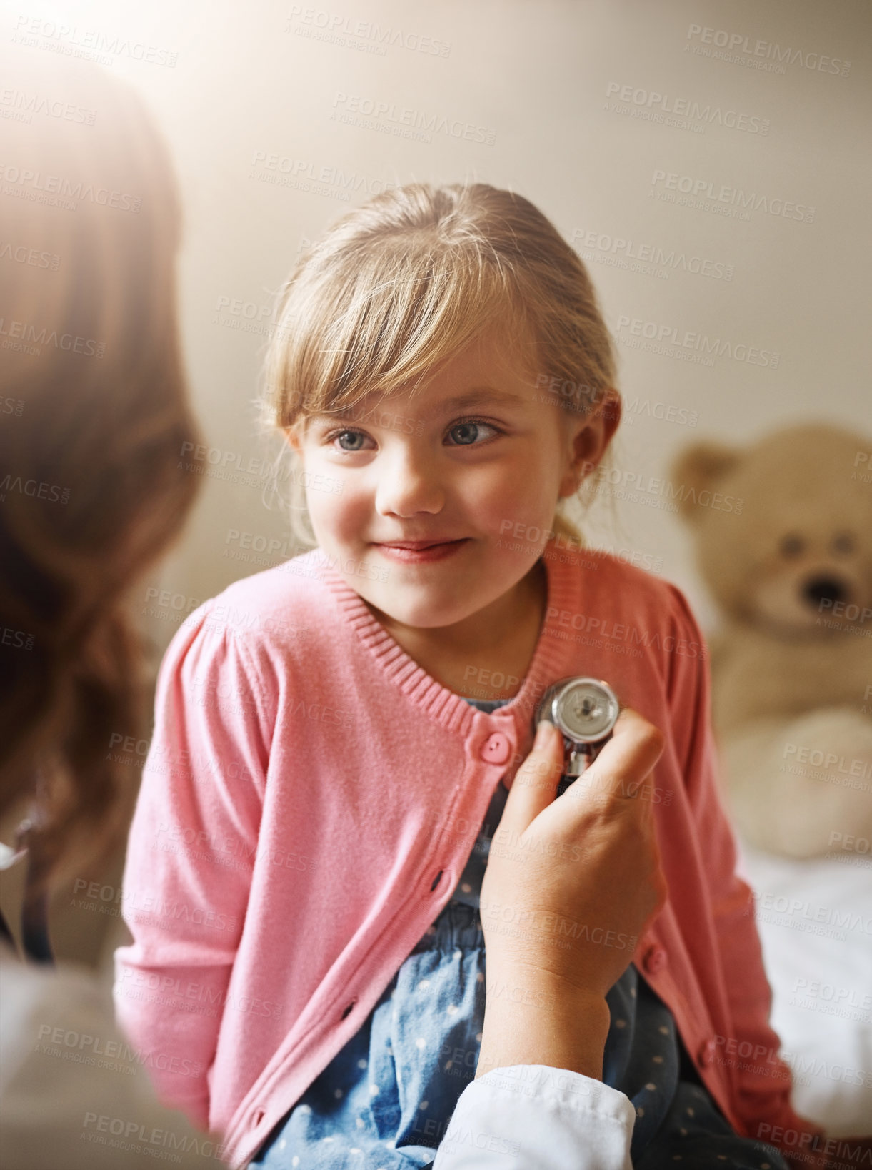 Buy stock photo Shot of a doctor examining a little girl with a stethoscope in her consulting room