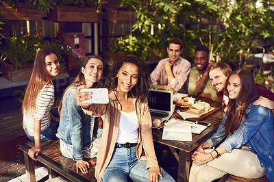 Buy stock photo Cropped shot of an attractive young woman taking a selfie while out for lunch with friends