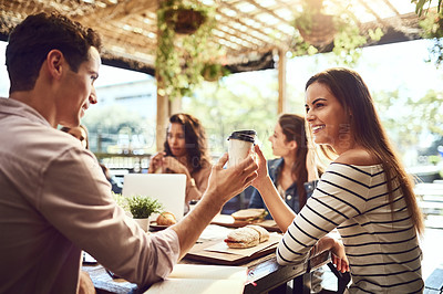 Buy stock photo Cropped shot of two friends toasting with coffee cups while out for lunch