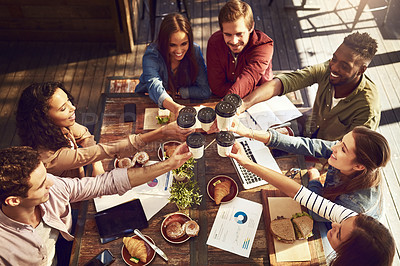 Buy stock photo High angle shot of a group of creative workers toasting with cups of coffee