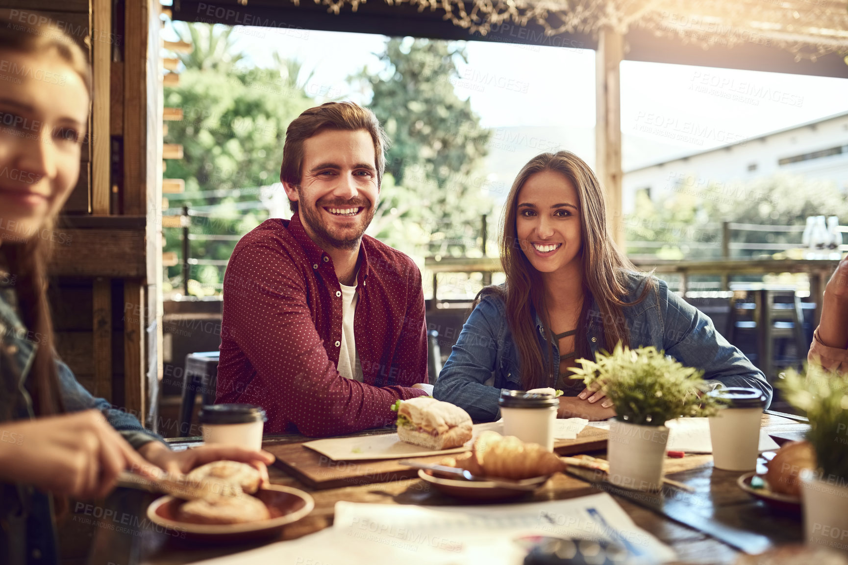 Buy stock photo Cropped portrait of an affectionate young couple out for lunch at a cafe with friends