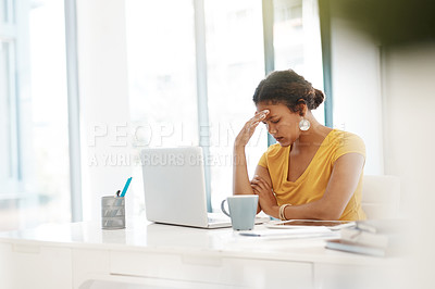 Buy stock photo Shot of a young businesswoman experiencing stress at her desk in a modern office