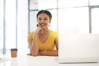 Buy stock photo Portrait of a confident young businesswoman working at her desk in a modern office