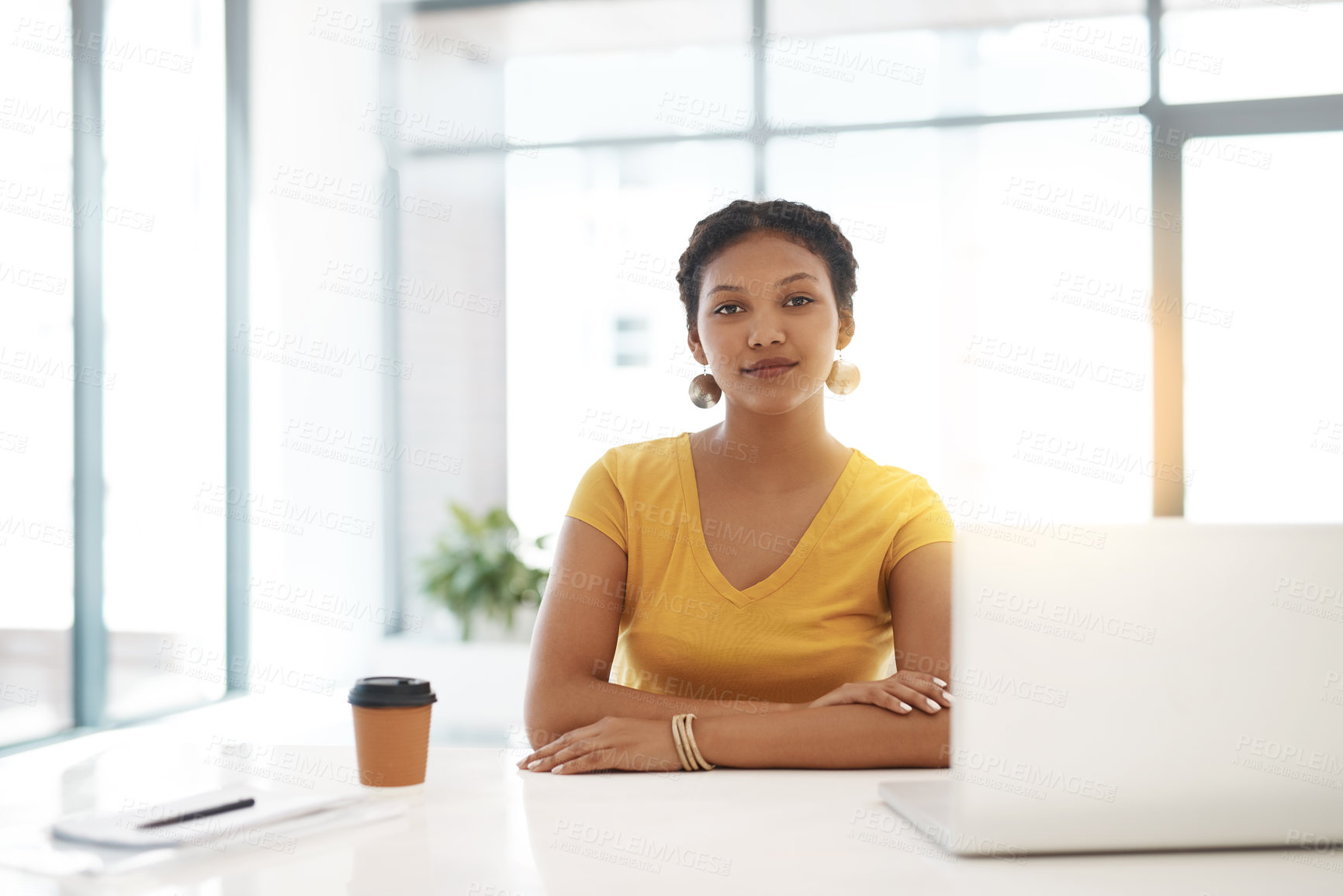 Buy stock photo Portrait of a confident young businesswoman working at her desk in a modern office