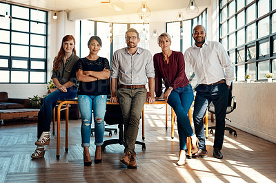 Buy stock photo Portrait of a group of confident businesspeople standing together in a modern office