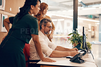 Buy stock photo Shot of a group of businesspeople using a computer together in a modern office