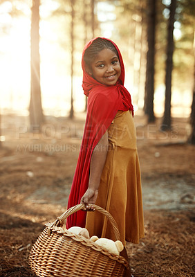 Buy stock photo Happy child, red and basket in forest for portrait, adventure and fairytale fantasy in nature. Girl, hamper or hood in woods for story themed birthday party, magic or cosplay at trees with creativity