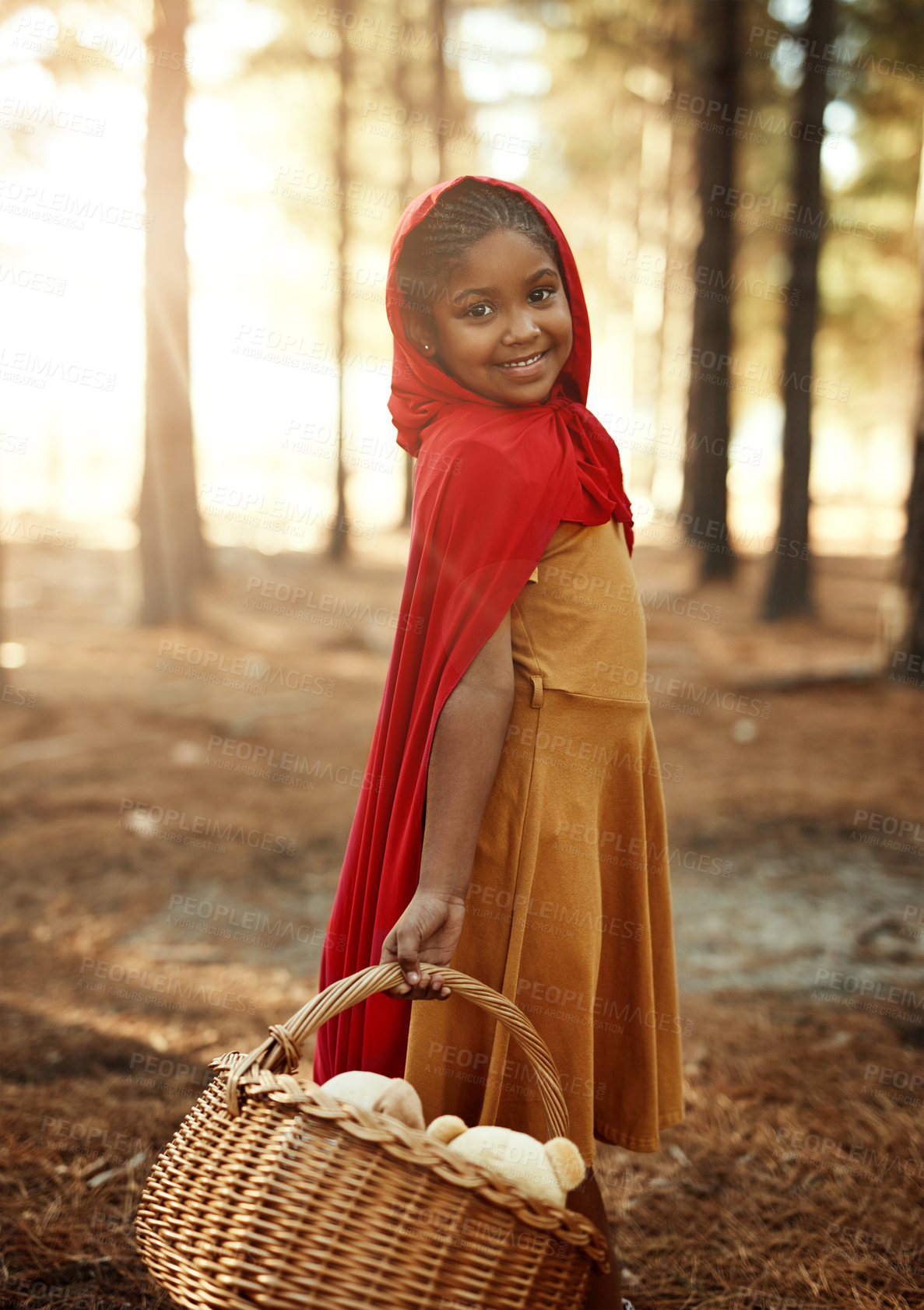 Buy stock photo Happy child, red and basket in forest for portrait, adventure and fairytale fantasy in nature. Girl, hamper or hood in woods for story themed birthday party, magic or cosplay at trees with creativity