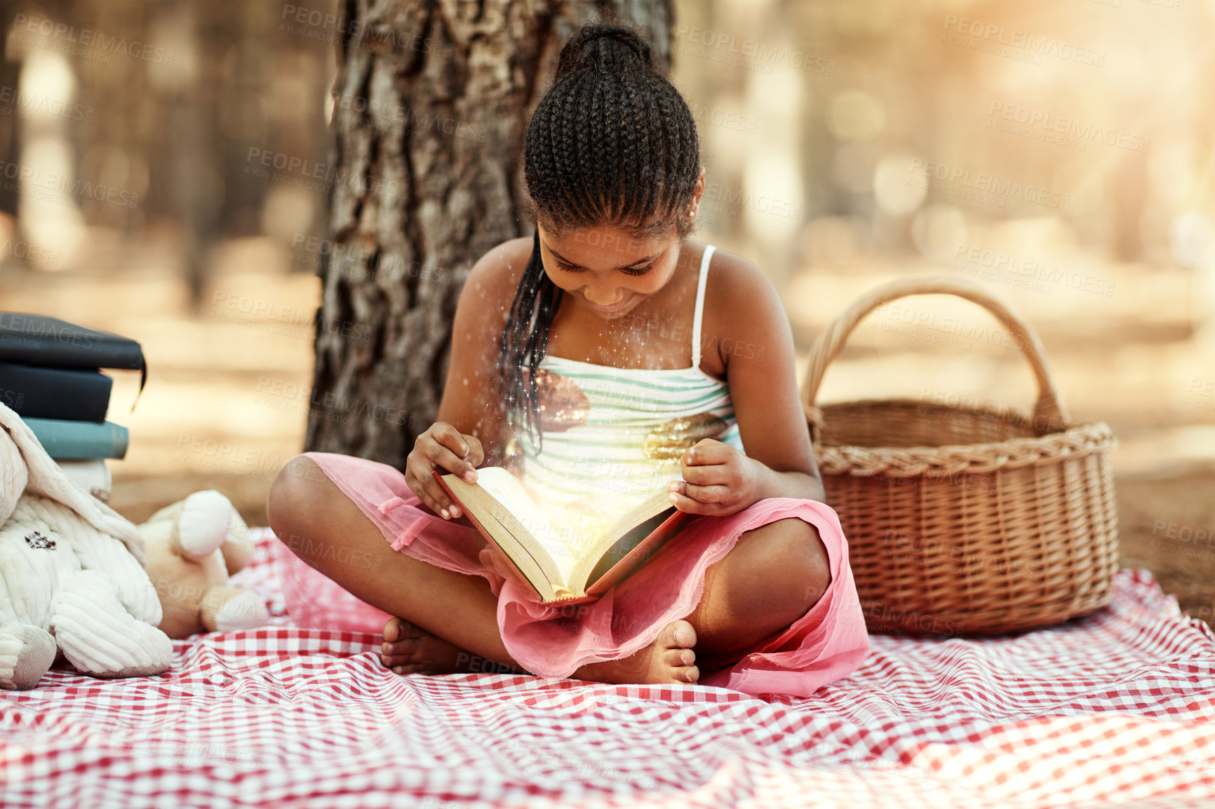 Buy stock photo Magic, girl and reading book on picnic at park for story, fantasy and novel for child development. Female person, outdoor and smile with toys at forest on break for education, literacy and learn