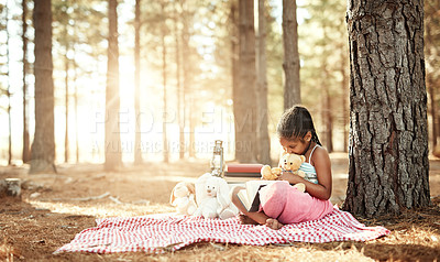 Buy stock photo African child, relax and reading book outdoor for learning, study or education in forest. Picnic blanket, park and girl with story, magic fairytale or fantasy for knowledge on holiday with teddy bear