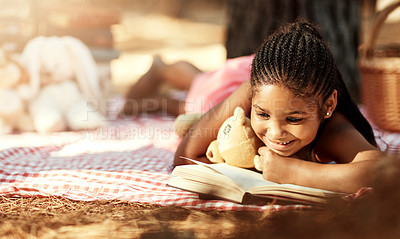 Buy stock photo Shot of a little girl reading a book with her toys in the woods