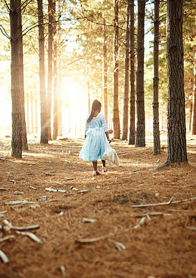 Buy stock photo Rear view shot of a little girl walking in the woods with her teddybear