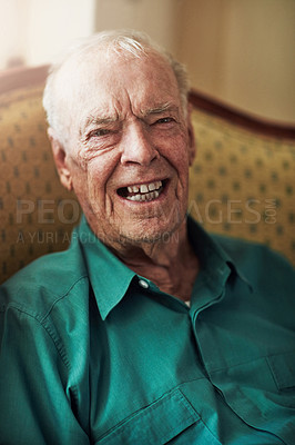 Buy stock photo Cropped portrait of a happy senior man sitting by himself in a living room