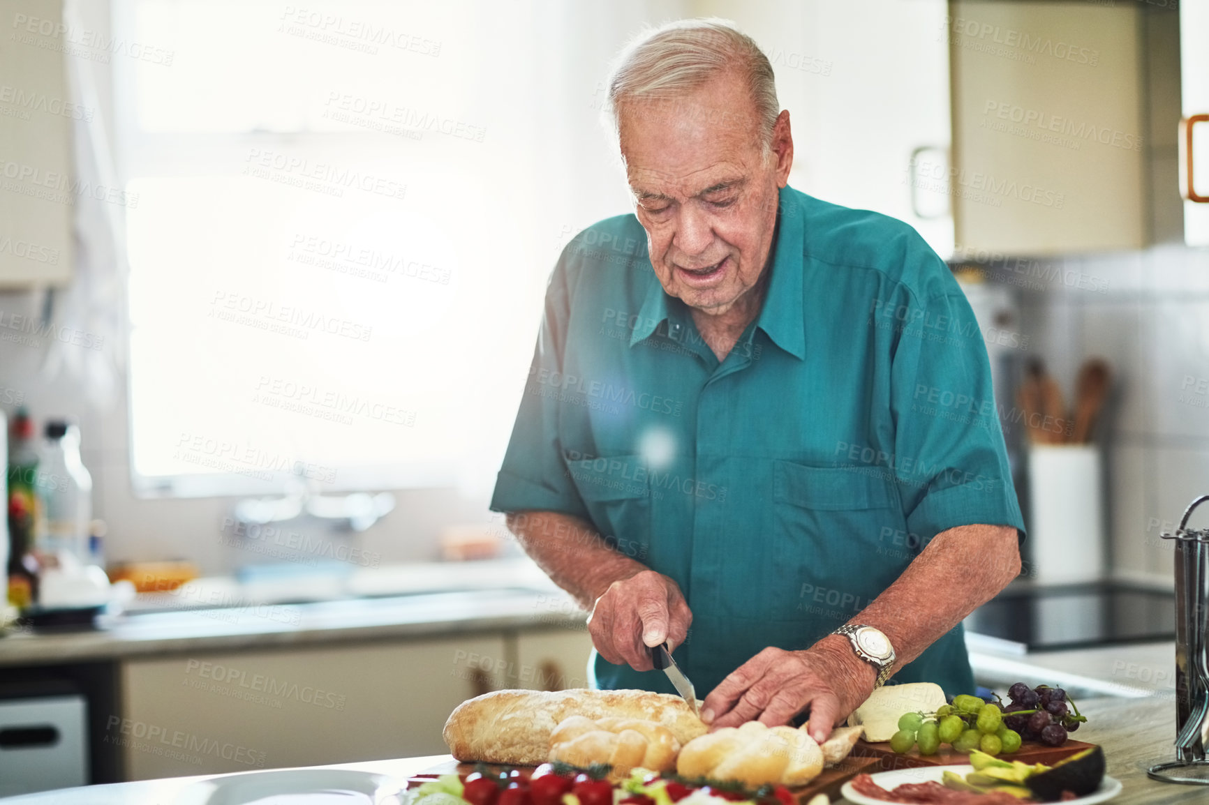 Buy stock photo Cropped shot of a senior man making lunch in his kitchen at home