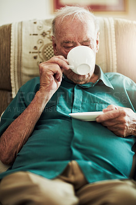 Buy stock photo Cropped shot of a senior man drinking tea while sitting by himself in a living room