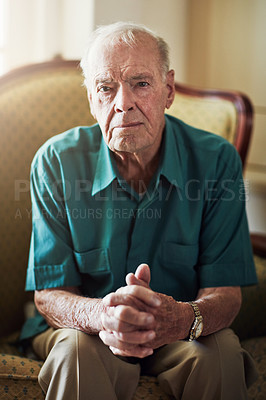 Buy stock photo Cropped portrait of a senior man sitting by himself in a living room