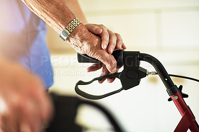 Buy stock photo Cropped shot of an unrecognizable female nurse assisting her senior patient who's using a walker for support