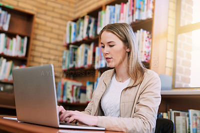 Buy stock photo Research, typing and woman in library with laptop, education and exam preparation at university. Female student, technology and studying at table for knowledge, communication and learning on internet