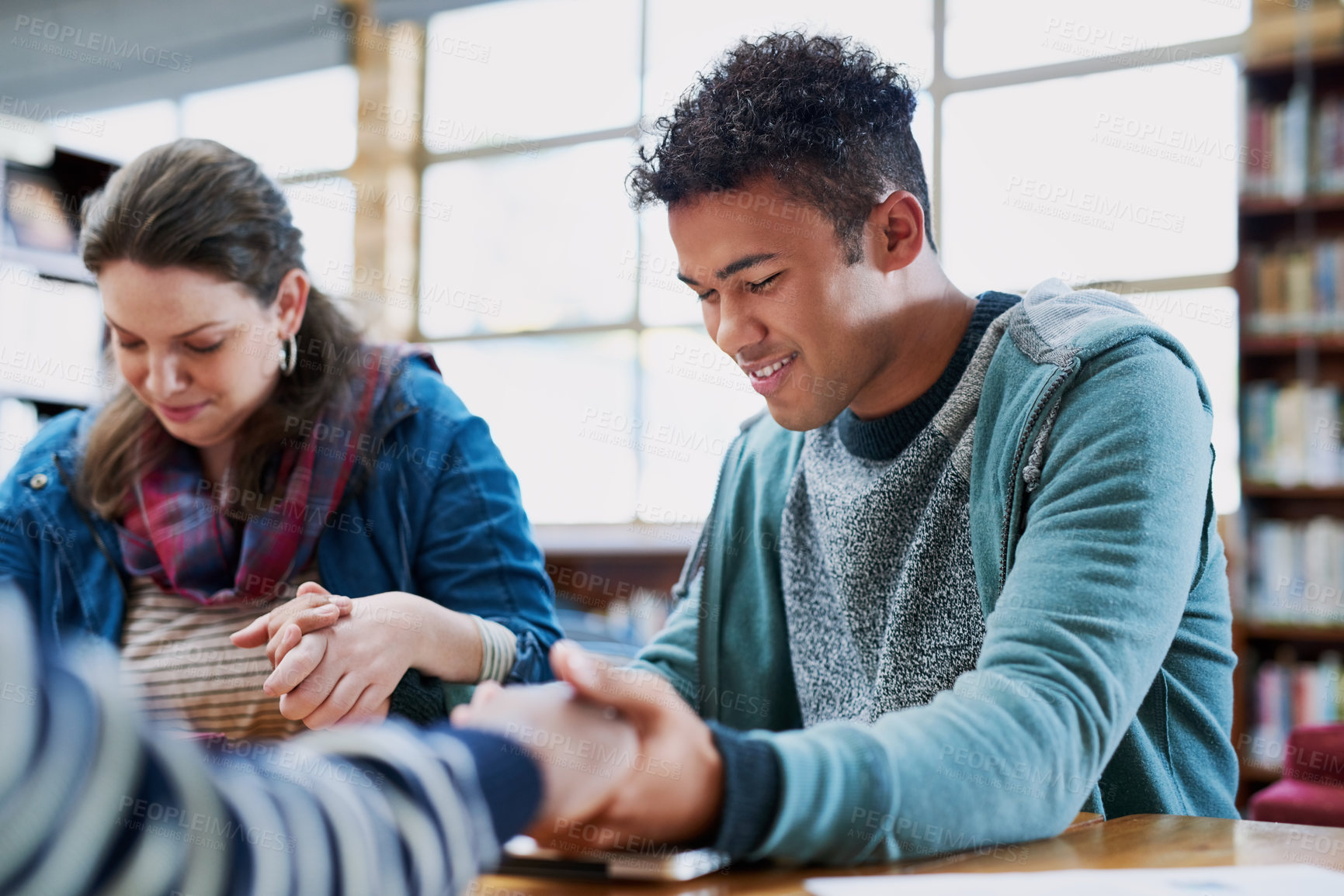 Buy stock photo Group, people or holding hands in prayer in support for blessings, grace or guidance in library. Smile, happy friends and hope with spirituality for school, college or teamwork for studying for exams