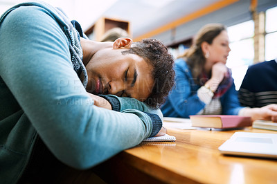 Buy stock photo Man, student and sleep in library with group, burnout and tired with books, tech and education at college. Person, fatigue and exhausted with studying, learning and development in hall at university