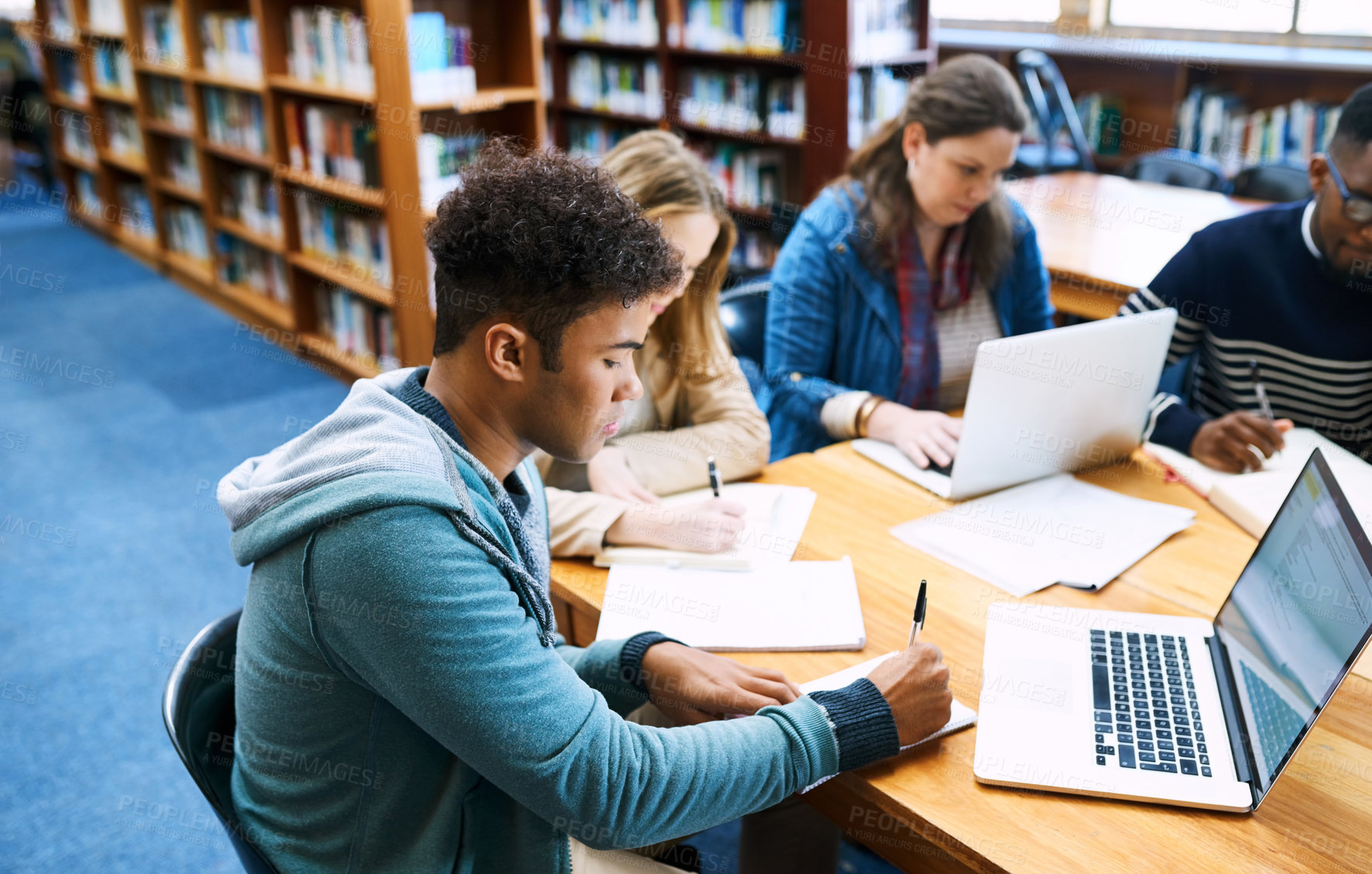 Buy stock photo Cropped shot of a group of university student studying hard in a library