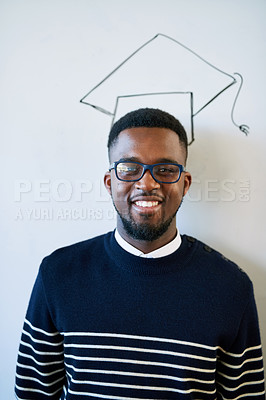 Buy stock photo Cropped portrait of a young university student standing against a whiteboard with a graduation cap drawn on it