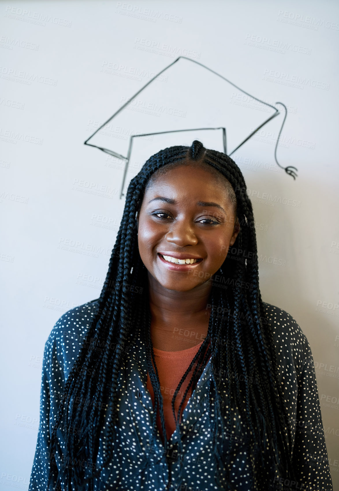 Buy stock photo Cropped portrait of a young university student standing against a whiteboard with a graduation cap drawn on it