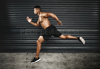 Buy stock photo Shot of a fit and shirtless young man running