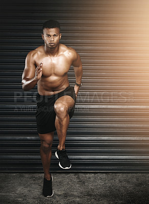 Buy stock photo Shot of a fit and shirtless young man running