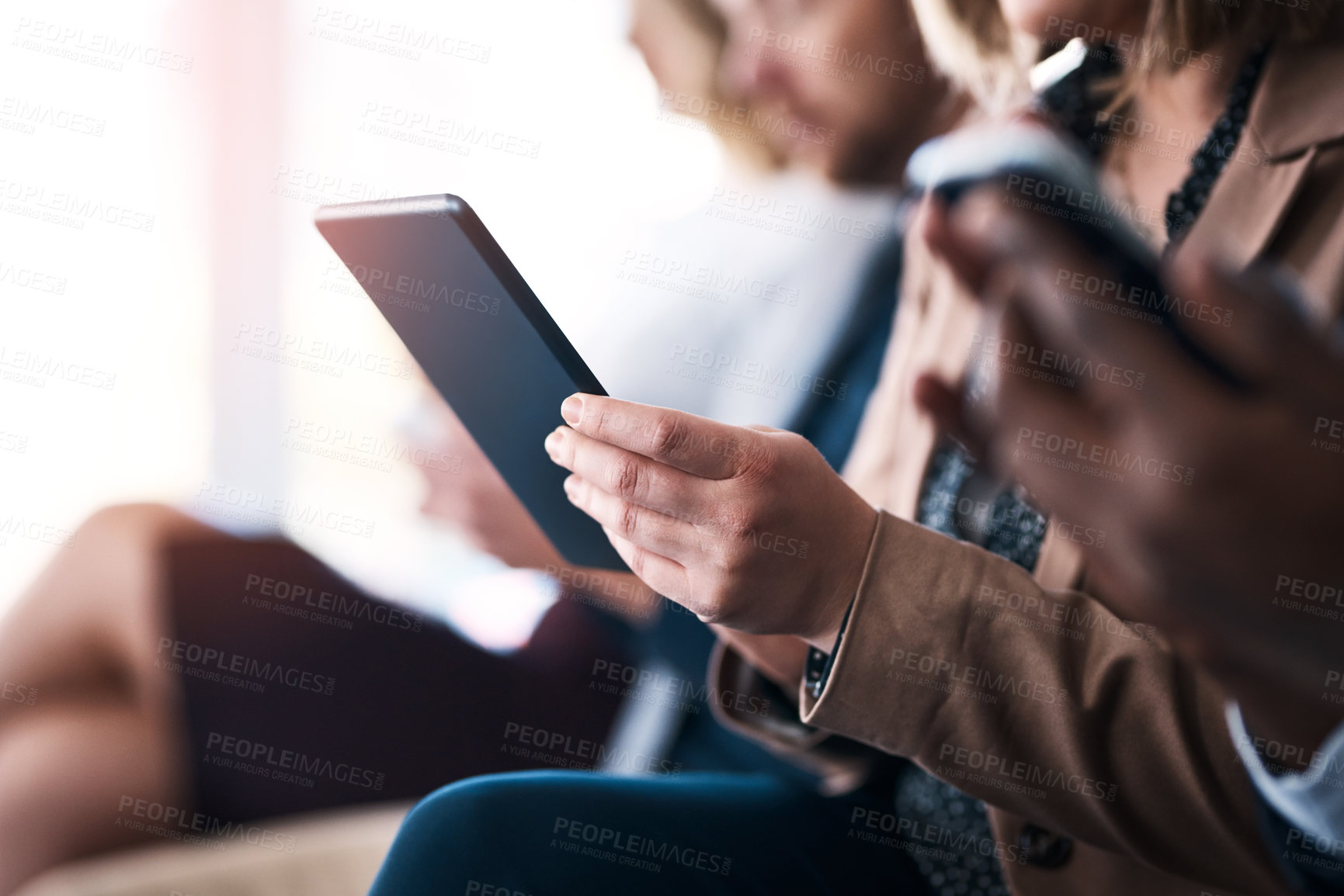 Buy stock photo Cropped shot of an unrecognizable young businesswoman using her digital tablet while sitting in a meeting