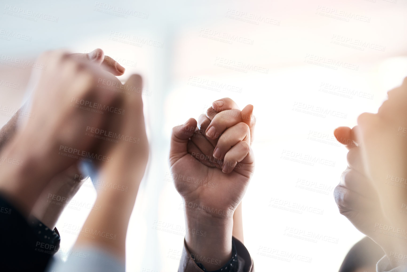 Buy stock photo Cropped shot of a group of unrecognizable businesspeople holding and raising their hands in the office