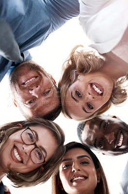 Buy stock photo Low angle portrait of a group of coworkers looking down at the camera while standing in a huddle