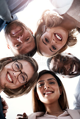 Buy stock photo Low angle portrait of a group of coworkers looking down at the camera while standing in a huddle