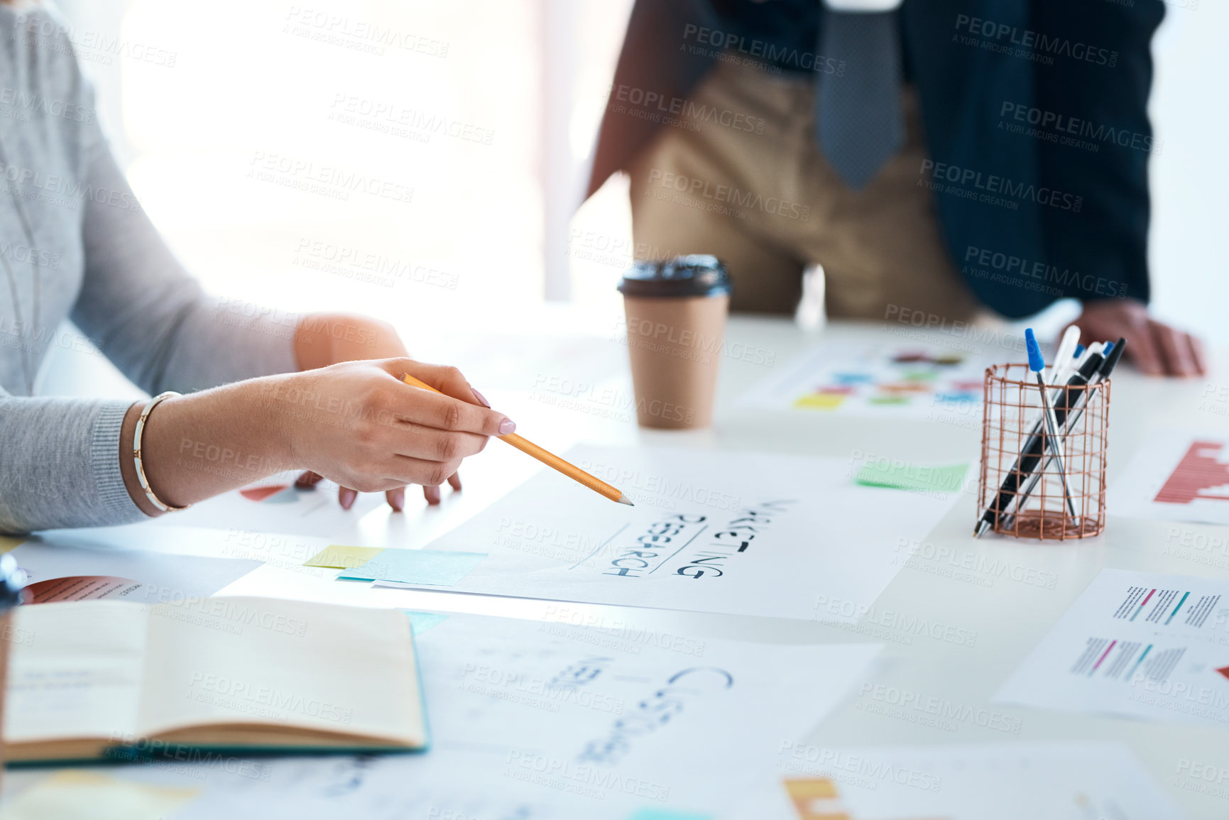 Buy stock photo Cropped shot of an unrecognizable businesswoman working on some paperwork during a meeting in an office