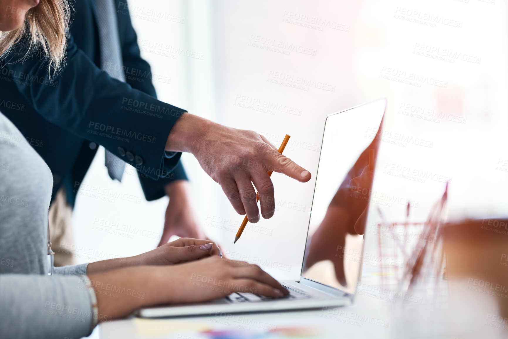 Buy stock photo Cropped shot of two unrecognizable businesspeople discussing something over a laptop