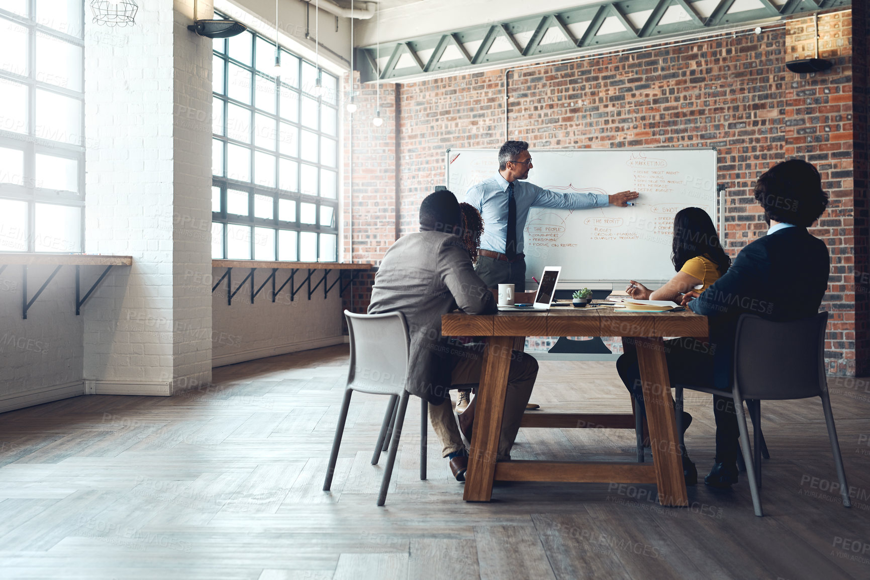 Buy stock photo Shot of a mature businessman giving a presentation to his colleagues in an office