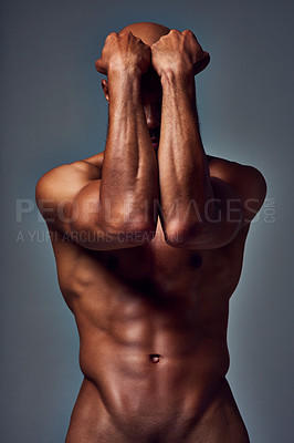 Buy stock photo Studio shot of an unrecognizable muscular young man posing nude with his arms covering his face against a grey background