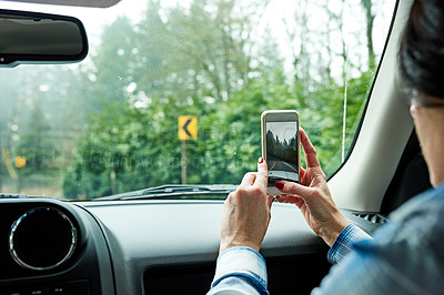 Buy stock photo Cropped shot of a passenger taking pictures while out on a road trip