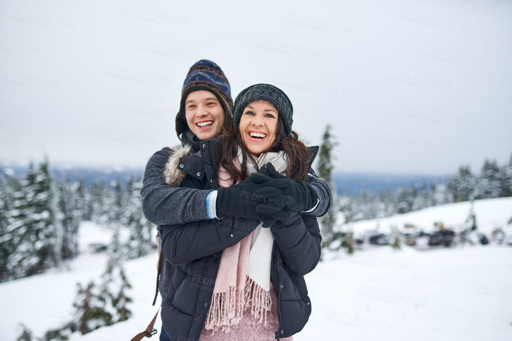 Buy stock photo Shot of a happy young couple enjoying themselves while being out in the snow