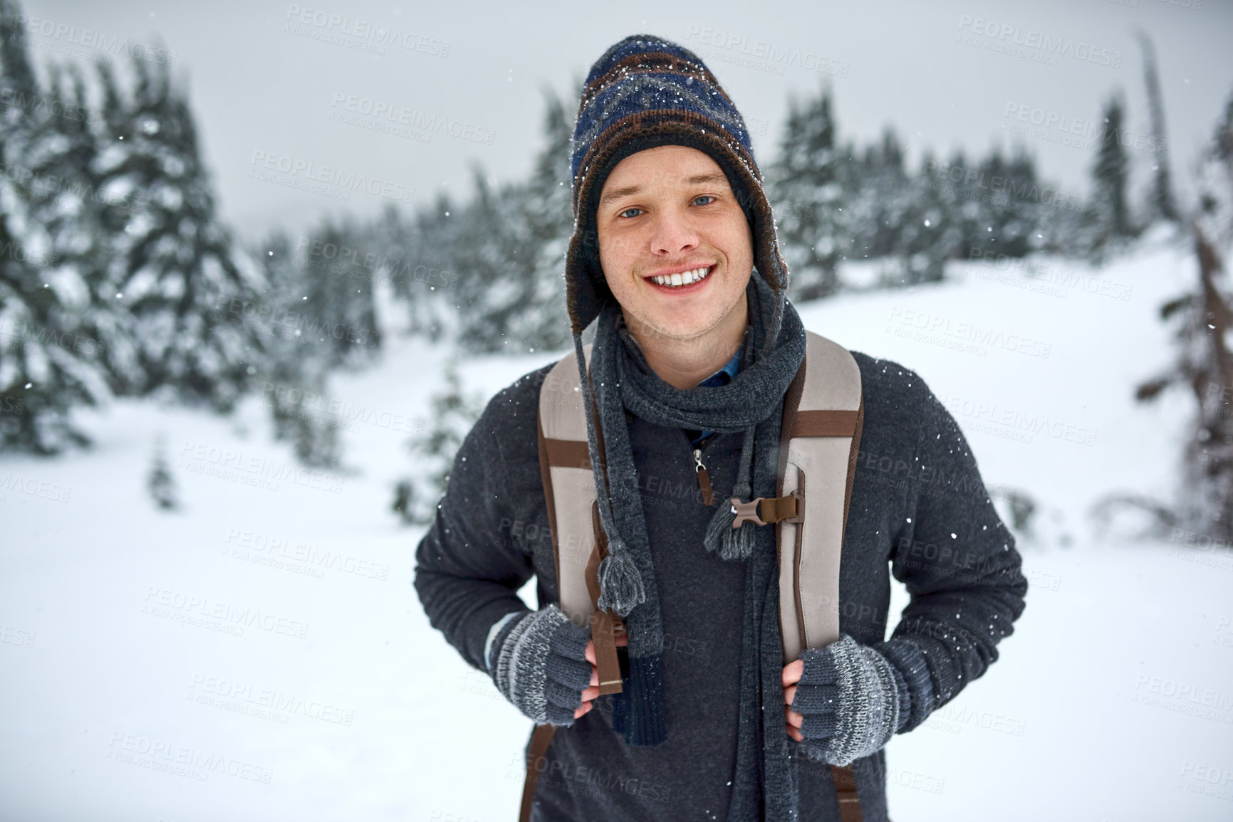 Buy stock photo Shot of a handsome young man spending the day out in the snow