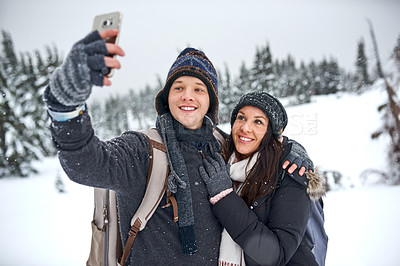 Buy stock photo Cropped shot of a man taking a selfie with his girlfriend while out on the snow