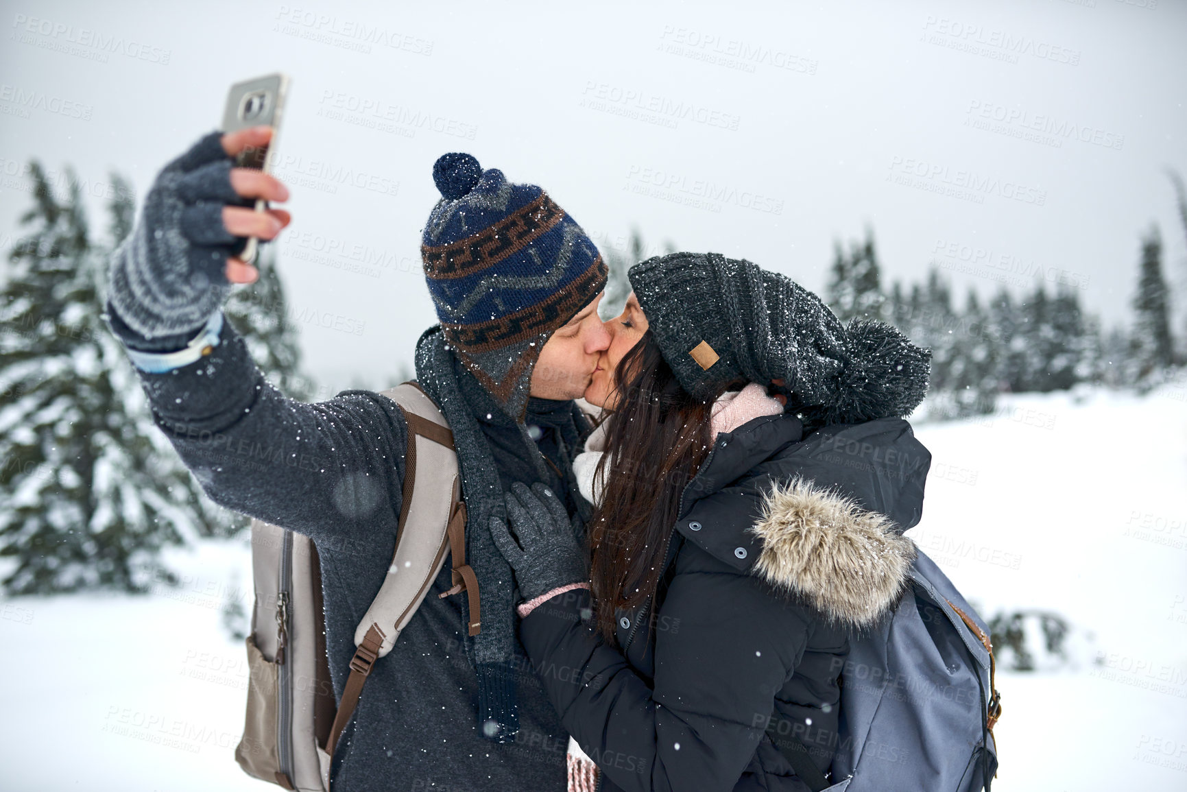 Buy stock photo Cropped shot of a man taking a selfie with his girlfriend while out on the snow