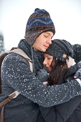 Buy stock photo Shot of a happy young couple enjoying themselves while being out in the snow