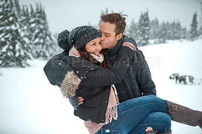 Buy stock photo Winter, snow and couple with kiss for carrying, travel adventure and bonding outdoor with hiking journey. Cold season, woman and man with affection for holiday vacation, location and happy in Canada