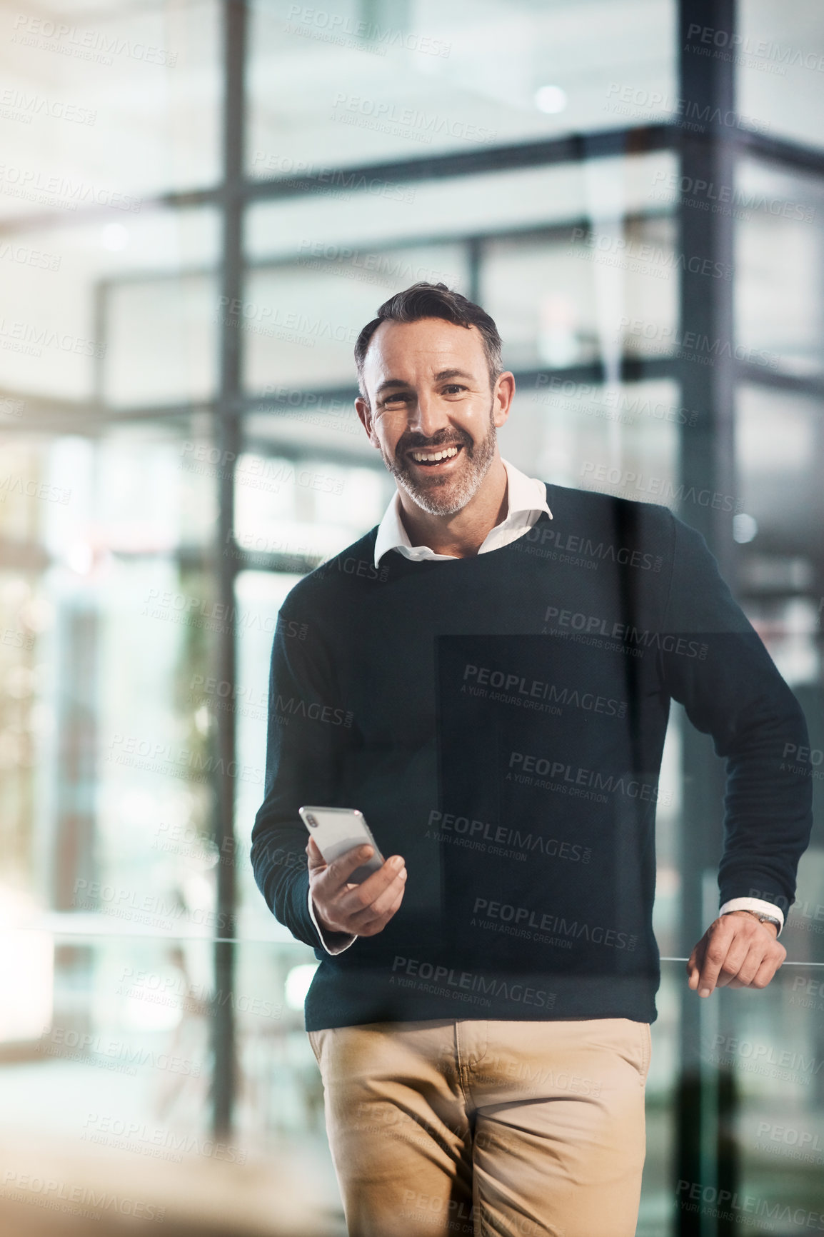 Buy stock photo Portrait of a mature businessman using a mobile phone in a modern office