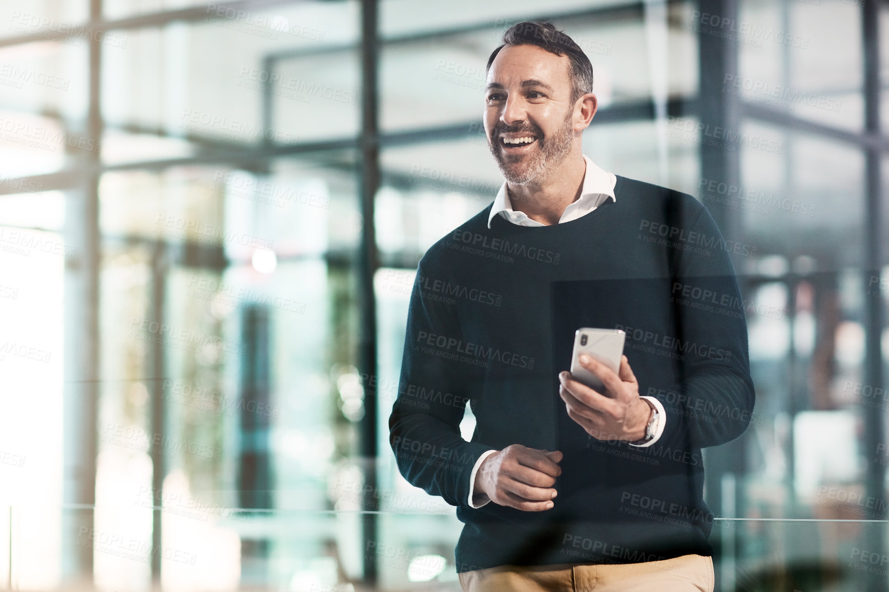 Buy stock photo Shot of a mature businessman using a mobile phone in a modern office