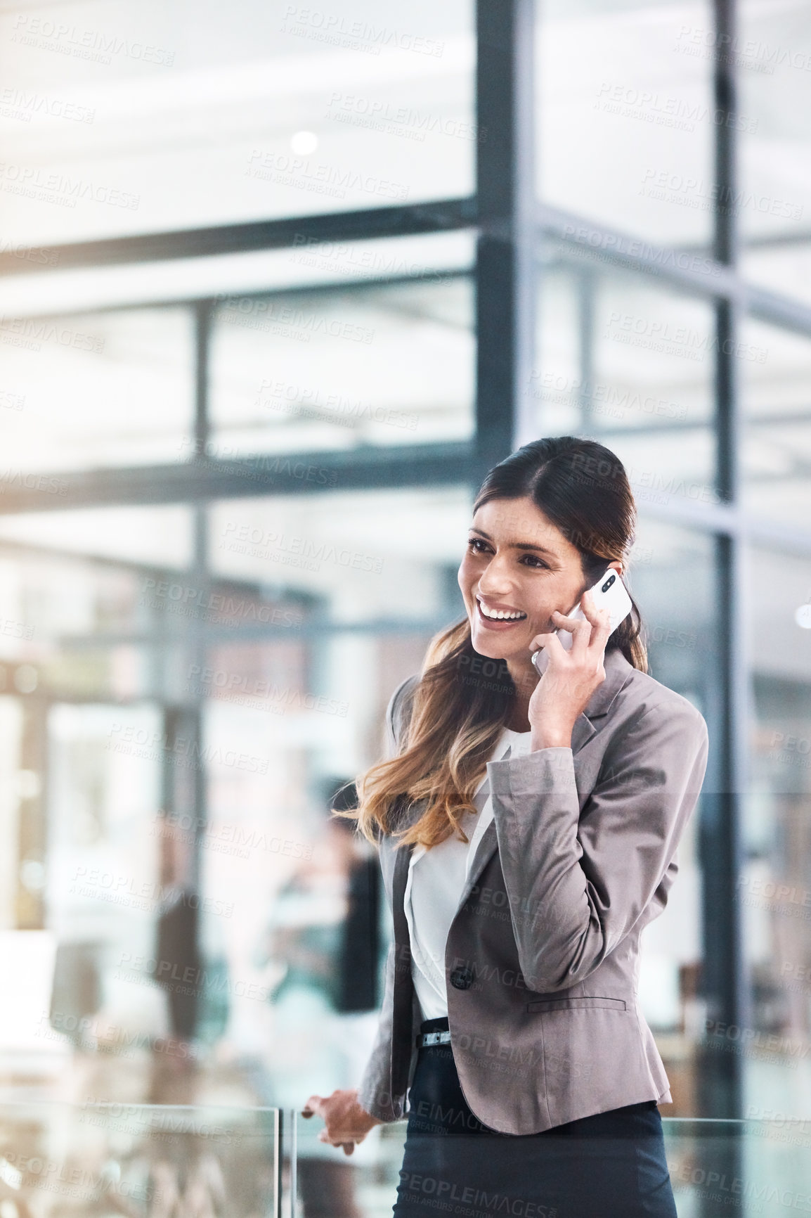 Buy stock photo Shot of a young businesswoman using a mobile phone in a modern office