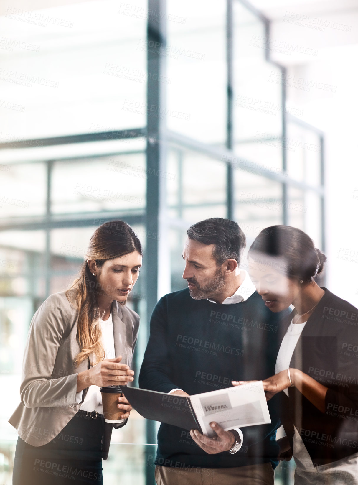 Buy stock photo Shot of a group of businesspeople discussing paperwork in a modern office