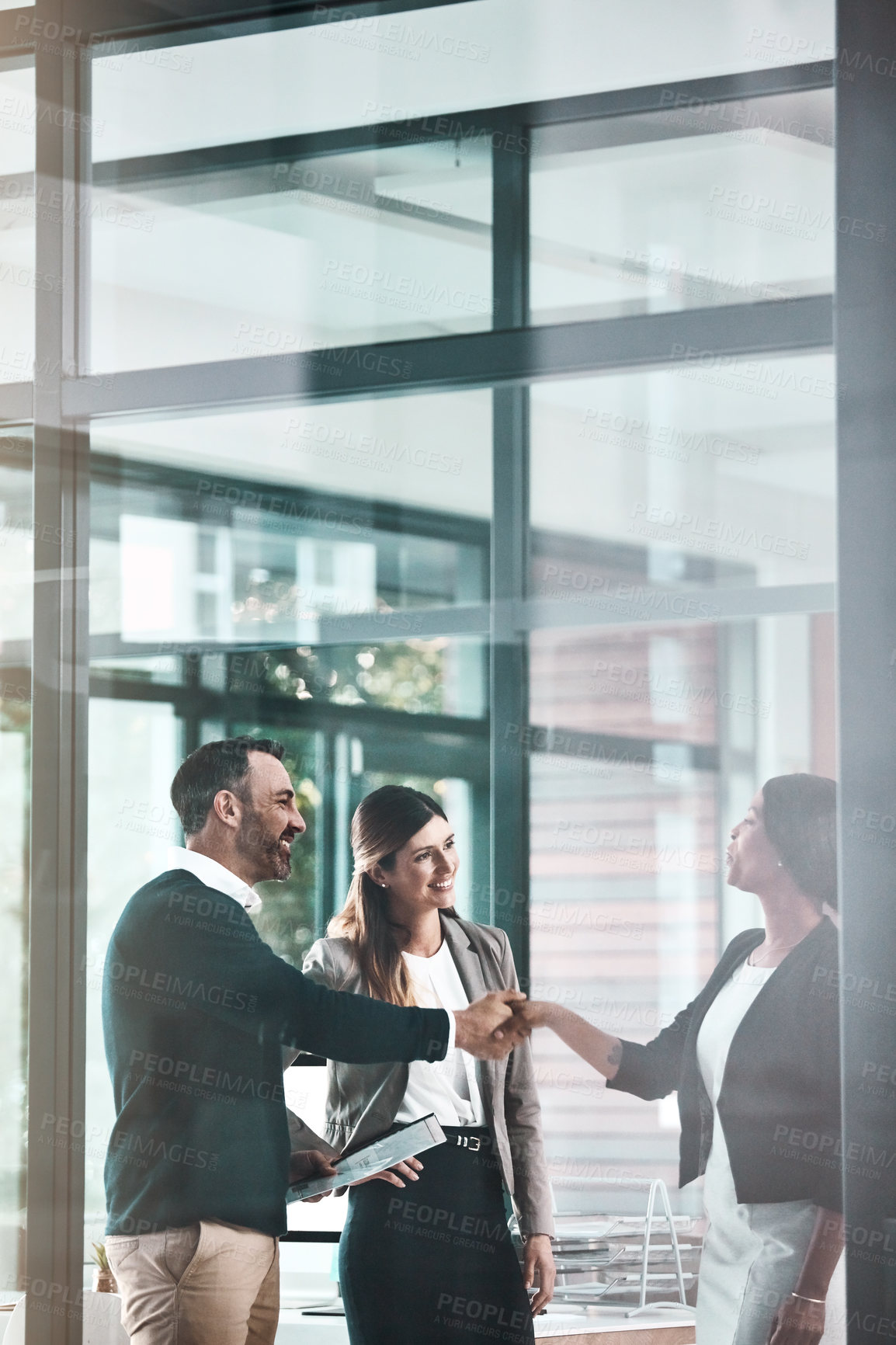 Buy stock photo Shot of a businessman and businesswoman shaking hands in a modern office