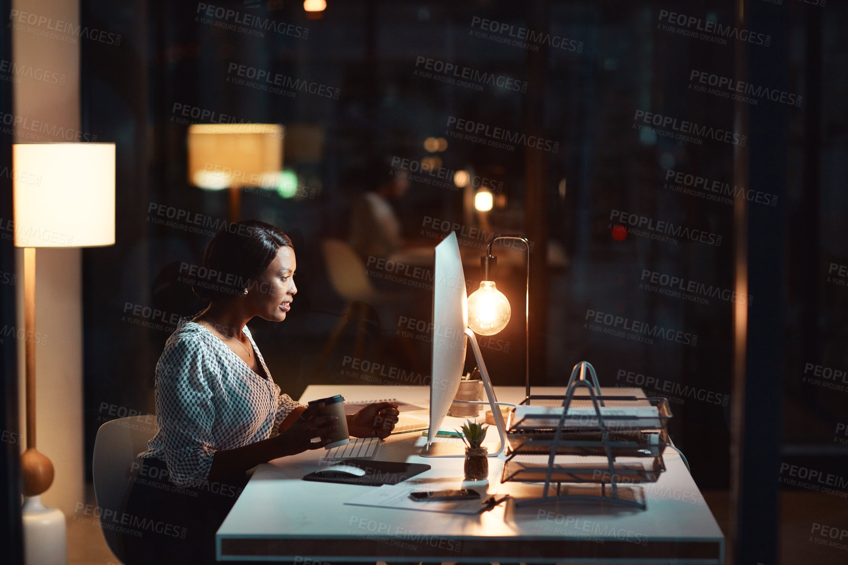 Buy stock photo Shot of a young businesswoman using a computer during a late night at work